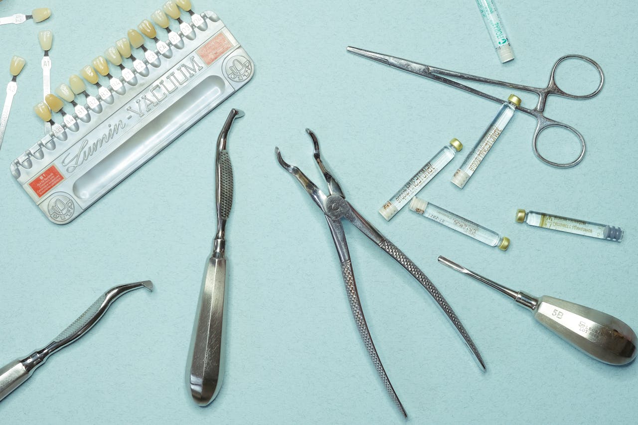 about-us Overhead shot of various dental tools and materials arranged on a blue background.